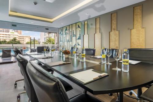 a conference room with a long table and chairs at Golden Tulip Mandison Suites in Bangkok