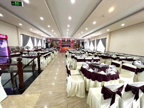 a banquet hall with white tables and white chairs at Hương Toàn 2 Hotel in Phu Quoc