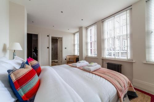 a bedroom with a large white bed with towels on it at Primary Located Splendid 2BR flat near Hyde Park in London