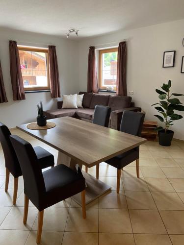 a living room with a wooden table and chairs at Riverside in Alpbach