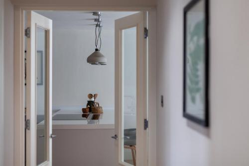 a hallway with a mirror and a pendant light at Primary Located Splendid 2BR flat near Hyde Park in London