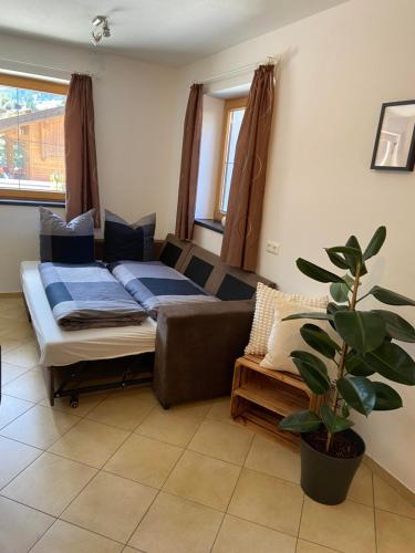 a living room with a couch and a plant at Riverside in Alpbach