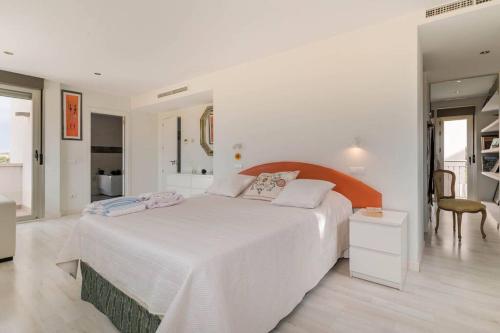 ein weißes Schlafzimmer mit einem großen Bett und einem Tisch in der Unterkunft Villa Oasis en Madrid con 3Hab, 4baños y elegante piscina in Villanueva del Pardillo