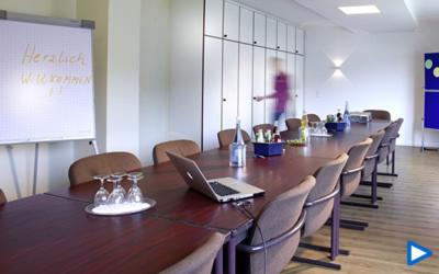 a conference room with a long table with a laptop on it at Hotel Villa am Rhein in Andernach