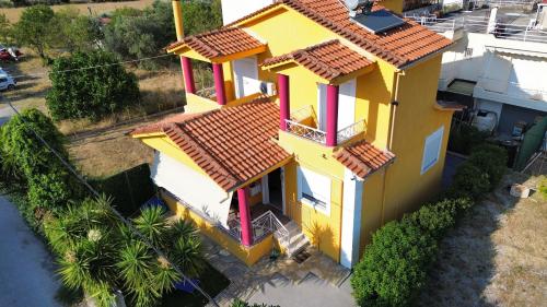 an overhead view of a yellow house with a red roof at The Sunny House in Kritharia