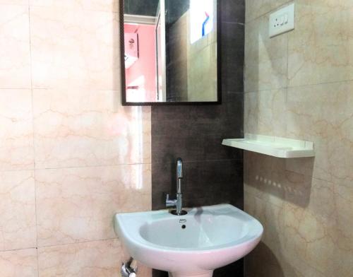 a bathroom with a white sink and a mirror at AYM Yoga Resort Arambol GOA in Arambol