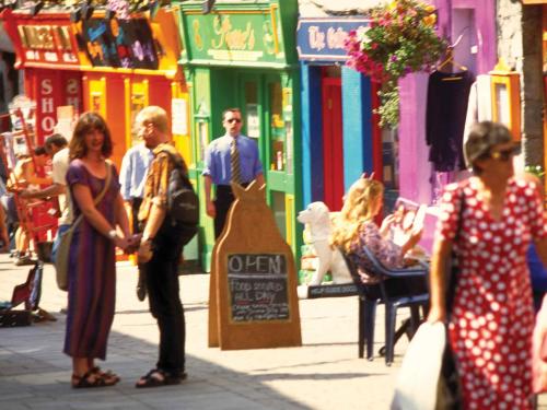 a group of people standing on a city street at Flannery's Hotel in Galway