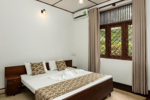 a bedroom with a bed and a window at Surveyor's Residence Bungalow in Kandy