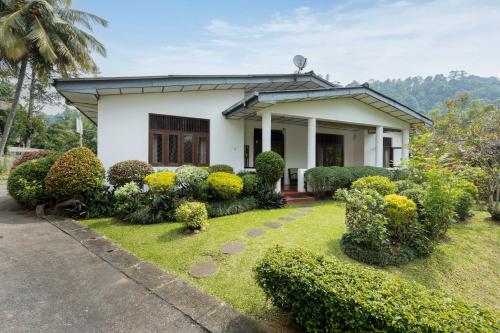 uma casa com um jardim em frente em Surveyor's Residence Bungalow em Kandy