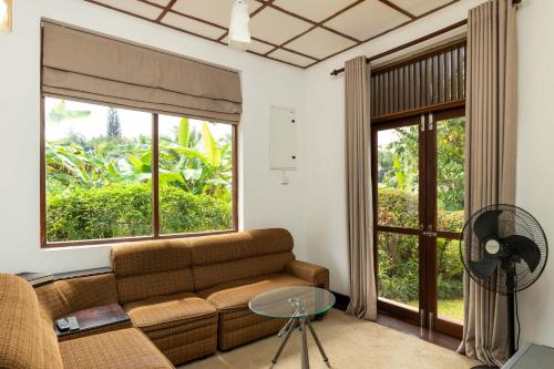 a living room with a couch and a glass table at Surveyor's Residence Bungalow in Kandy