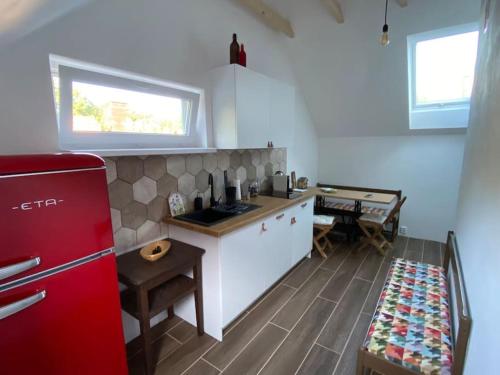 eine Küche mit einem roten Kühlschrank und einem Tisch in der Unterkunft Apartmán Králíček na vínné stezce in Dolní Bojanovice
