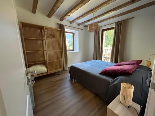 um quarto com uma cama com almofadas vermelhas em El Molí - Apartament Torreneules em Ribes de Freser