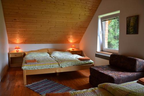 a bedroom with two beds and a chair and a window at Chata Pohoda Slovenský Raj Čingov in Spišské Tomášovce
