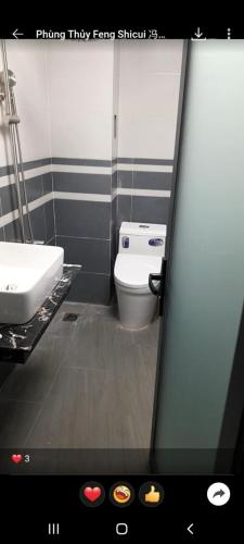 ein Badezimmer mit einem weißen WC und einem Waschbecken in der Unterkunft SCS HOTEL in Xóm Hương Phùng