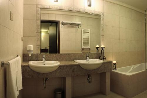 a bathroom with two sinks and a mirror and a tub at Ahotel in Czechowice-Dziedzice