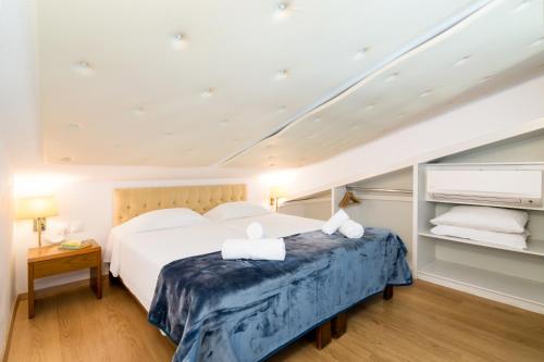 a bedroom with a large white bed and shelves at Helion Resort in Gouvia