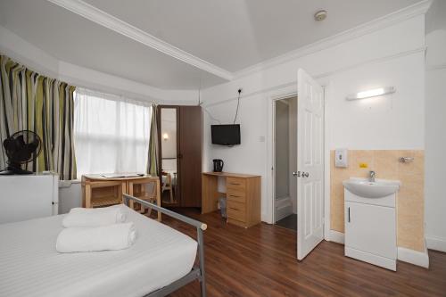 a bedroom with a bed and a sink and a bathroom at Flexistay Norbury Aparthotel in London
