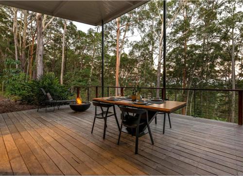 a wooden deck with a table and a fire place at Hunchy Escape - Hinterland Pet Friendly! in Montville