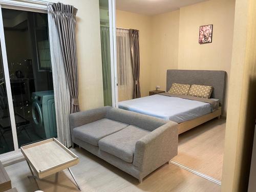a small bedroom with a bed and a couch at 《碧水莊園》亞洲公寓設計大獎一室一廳整套Bangkok曼谷拉差達新商業區火車夜市 in Bangkok