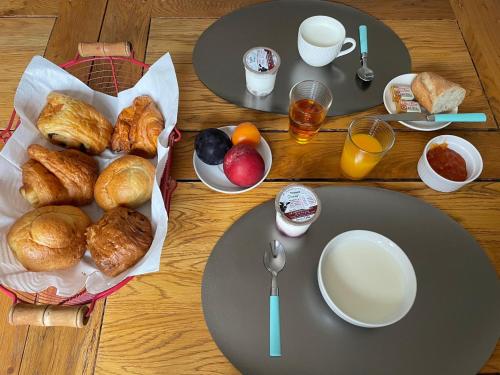 - une table en bois avec des assiettes de pâtisseries et des boissons dans l'établissement Le Double C, à Saint-Victor-de-Morestel