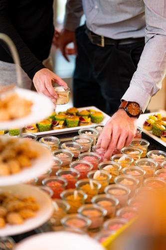 a person preparing food on a table with plates of food at Bio-Seehotel Zeulenroda in Zeulenroda