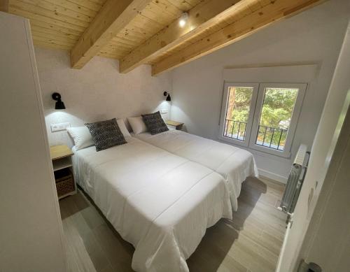 a large white bed in a room with a window at APARTAMENTOS AREKORATAS 255 y 256 