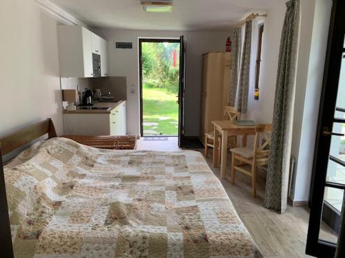 a bedroom with a bed and a kitchen and a table at Chalupa Krompach in Krompach