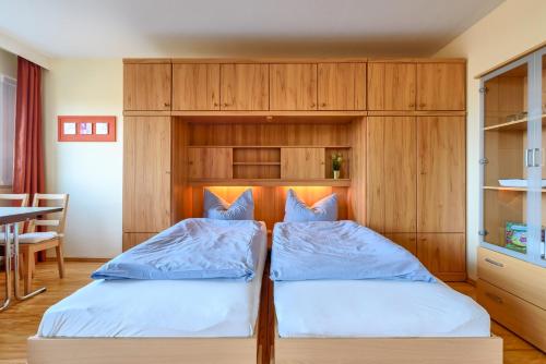2 Betten in einem Zimmer mit Holzschränken in der Unterkunft Berolina Wohnung 302 in Dahme