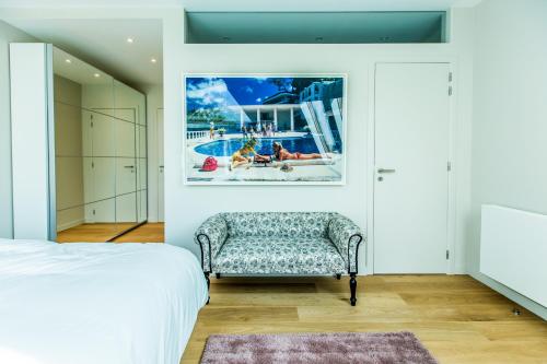 um quarto com um sofá e uma fotografia de uma piscina em Magnifique Penthouse 3 chambres et terrasse sur l'Avenue Louise em Bruxelas
