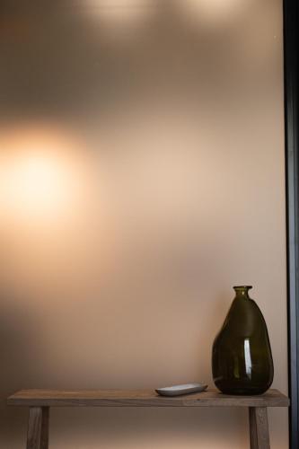 a vase sitting on a wooden shelf against a wall at The Sanctuary Urban Retreat in Rome