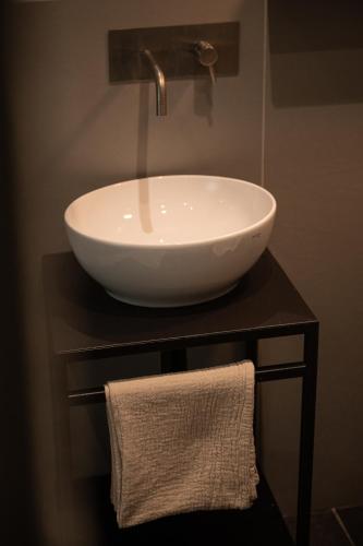 a white sink on a table with a towel at The Sanctuary Urban Retreat in Rome