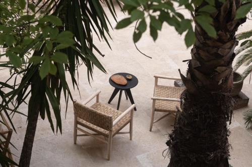 a patio with two chairs and a table and a palm tree at The Sanctuary Urban Retreat in Rome
