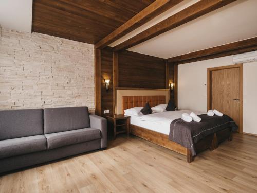 a bedroom with a bed and a couch at Hotel Victoria by VAYA in Kaprun