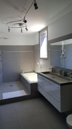 Baño blanco con lavabo y bañera en VILLA MONTPELLIER en Montpellier