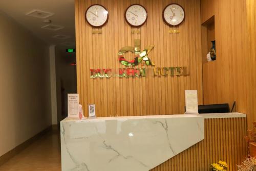 a lobby with clocks on the wall and a counter at Đức Khôi Hotel in Cao Bằng