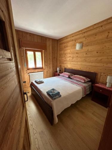 a bedroom with a bed in a wooden room at Casa Olivera in Limone Piemonte