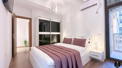 a white bedroom with a large bed and a window at Deluxe Criss Solid Residence Mamaia in Mamaia