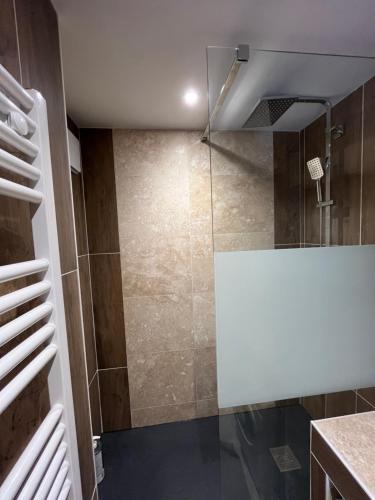 une douche avec une porte vitrée dans une salle de bain dans l'établissement F2 rénové, à Saint-Lary-Soulan