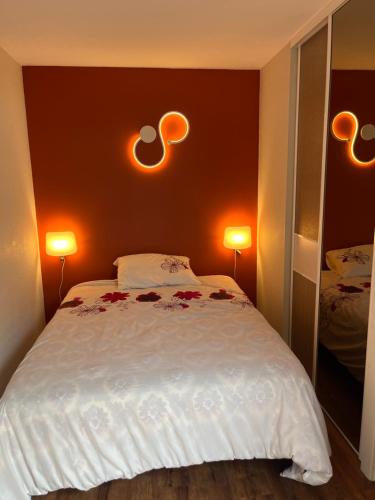 - une chambre avec un lit et deux lumières sur le mur dans l'établissement F2 rénové, à Saint-Lary-Soulan