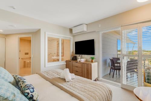 a bedroom with a bed and a flat screen tv at Quiet Apartment in Mantra Salt Beach by uHoliday - 2BR, 1BR and Hotel Room configurations available in Kingscliff