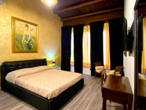 a bedroom with a bed and a table and window at Villa Margherita in Isola della Scala