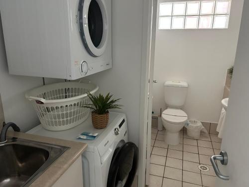 a small bathroom with a washing machine and a sink at Prime Position – Dream Holiday Unit in Caloundra!! in Caloundra