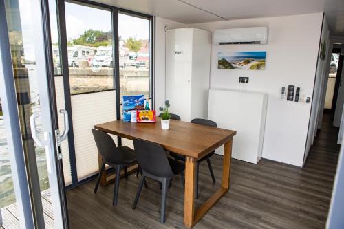 a dining room with a wooden table and chairs at Ostsee Hausboot Schleswig Ostseeblick 1 in Schleswig