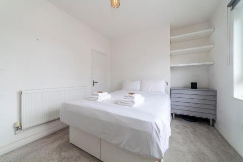 Trendy Spacious 2BR apt near London Bridge في لندن: غرفة نوم بيضاء مع سرير أبيض ومرآة
