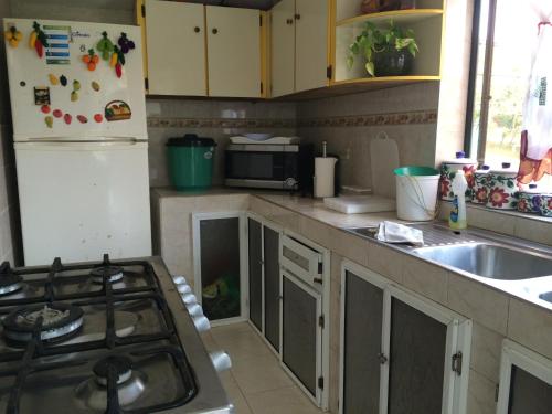 a kitchen with a stove and a sink and a refrigerator at Posada Miss Portia in Providencia