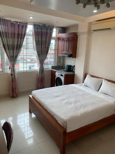 een slaapkamer met een groot bed en een keuken bij Li Homestay 136 Trần Bình, Mỹ Đình, Nam Từ Liêm, Hà Nội in Hanoi