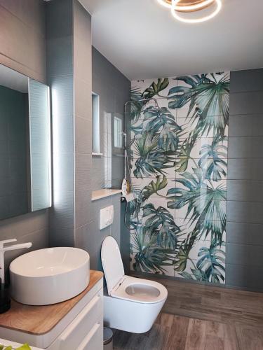 a bathroom with a sink and a toilet in it at Apartman Mala Lalina in Komin