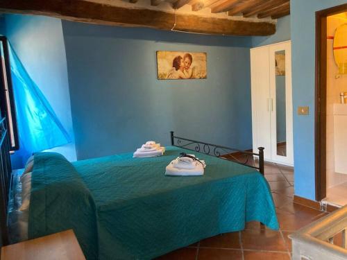 niebieska sypialnia z łóżkiem z ręcznikami w obiekcie Ai Muri Dipinti w mieście Perugia