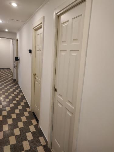 a hallway with two doors and a checkered floor at Stella Polare Sensorial Home in Lido di Ostia