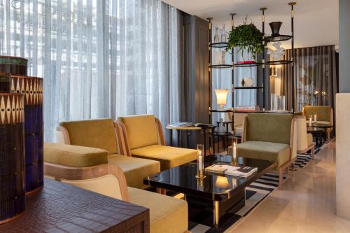 a living room with chairs and a couch and a table at Radisson Blu Hotel, London Bond Street in London
